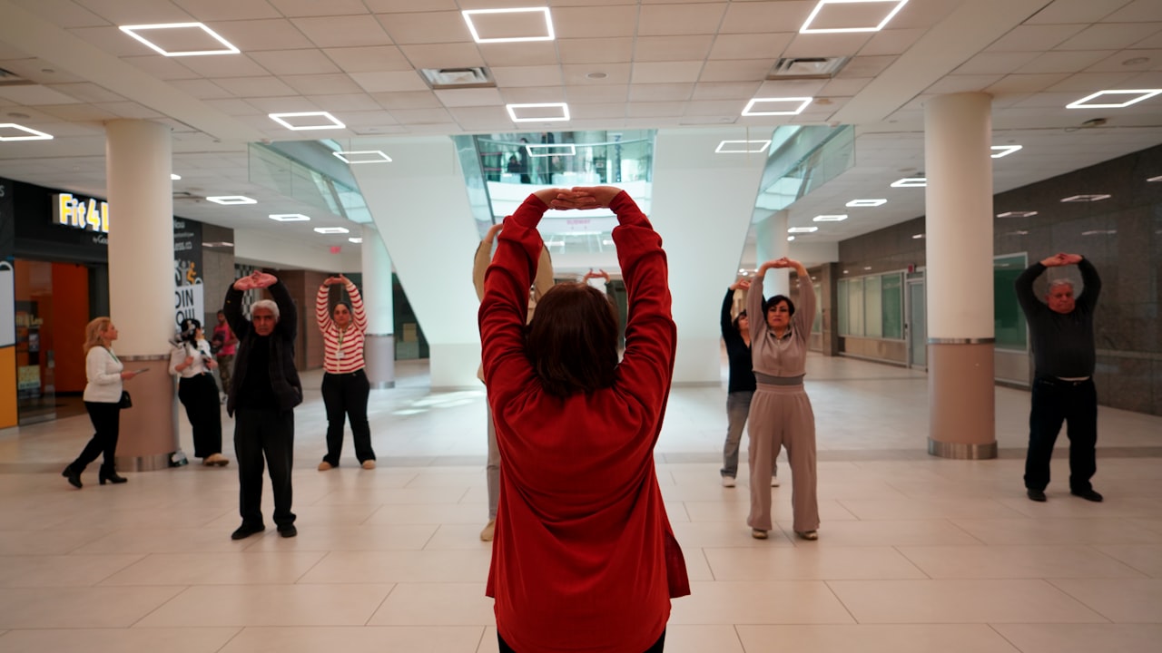 A group of older adults following along with a gentle Tai Chi class